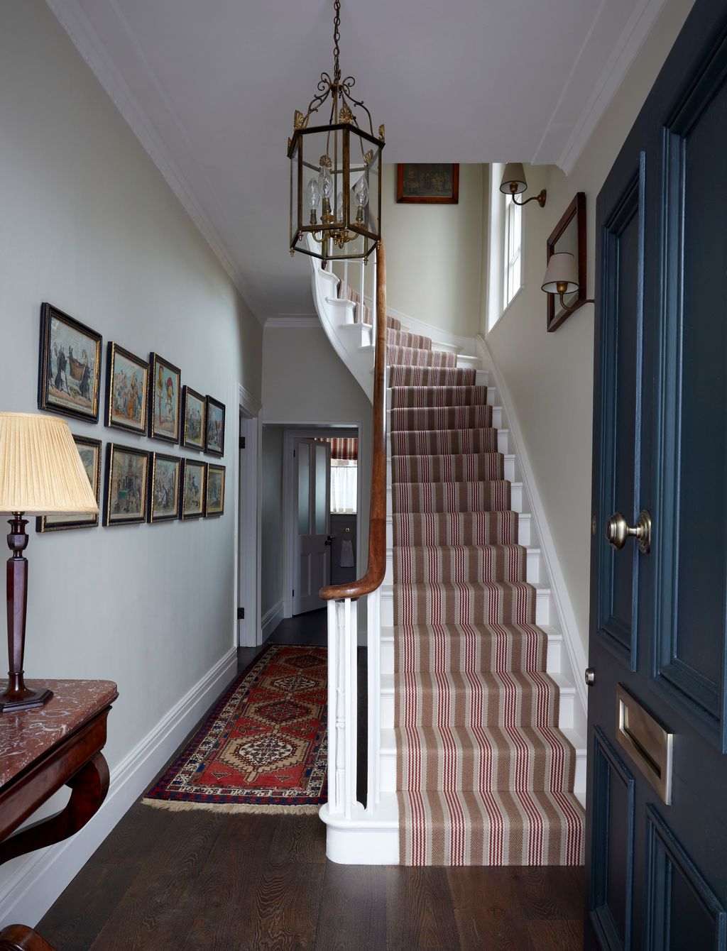 Image may contain Indoors Architecture Building Foyer Lamp Home Decor Rug Art and Painting