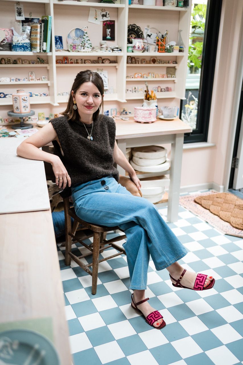 Image may contain Person Sitting Clothing Pants Footwear Sandal Adult Accessories Jewelry Necklace and Jeans