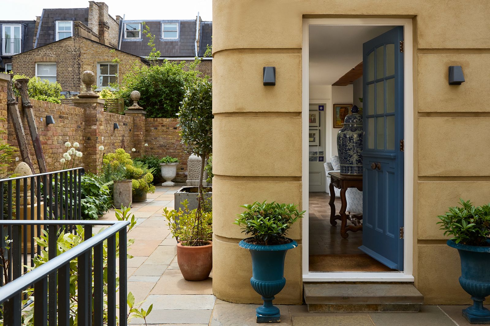 Image may contain Plant Desk Furniture Table Art Painting Architecture Balcony Building Housing Person and Door