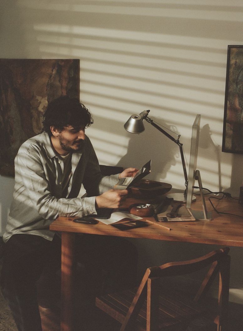Image may contain: Furniture, Table, Face, Head, Person, Photography, Portrait, Desk, Chair, Lamp, Adult, and Lighting