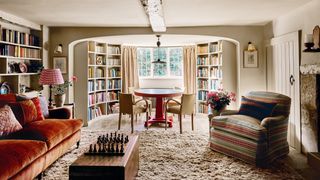 Image may contain Home Decor Lamp Chair Furniture Couch Desk Table Art Painting Rug Candle and Architecture