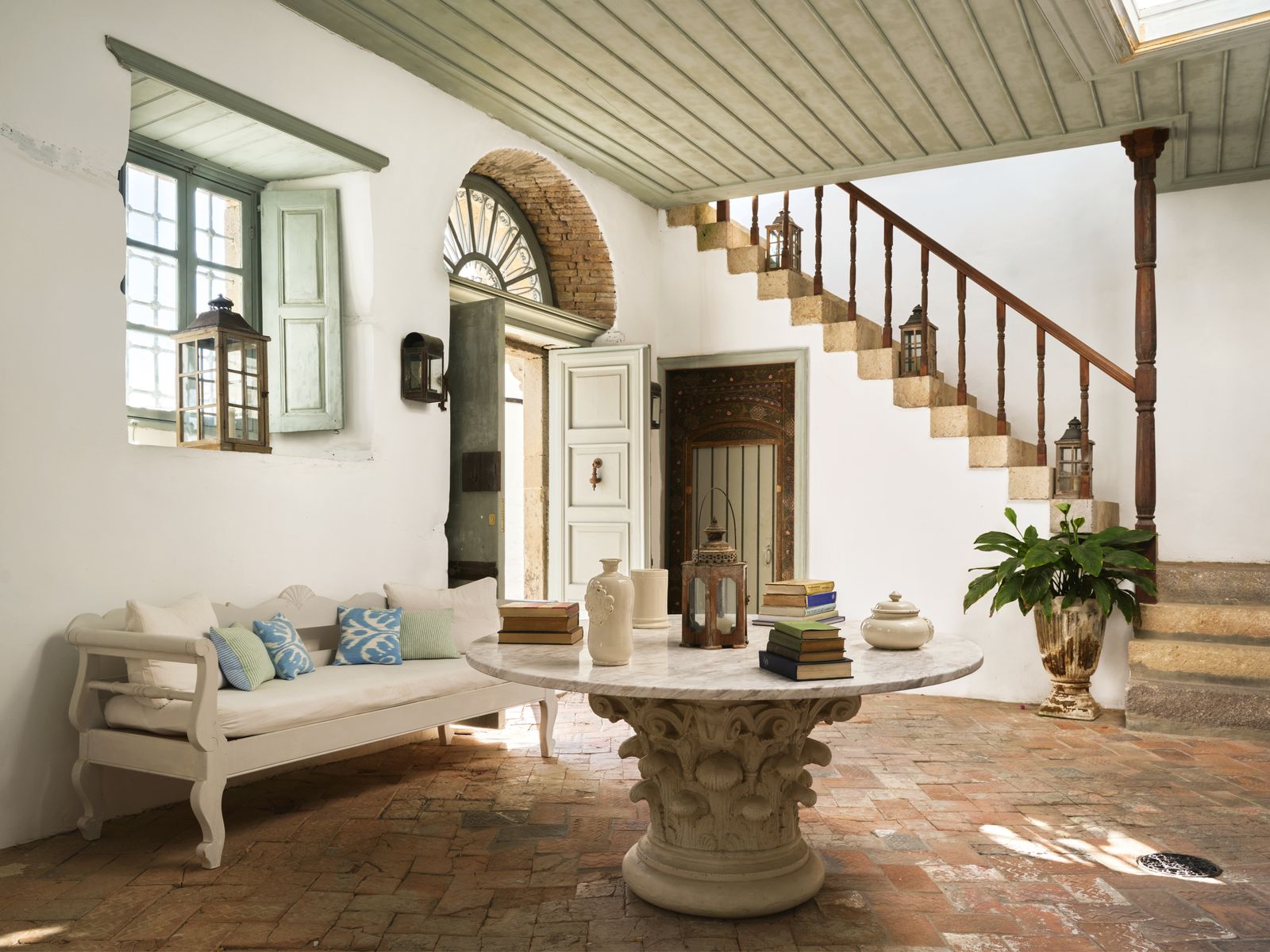 Image may contain Architecture Building Furniture Indoors Living Room Room Plant Foyer Desk Table Cup and Bench