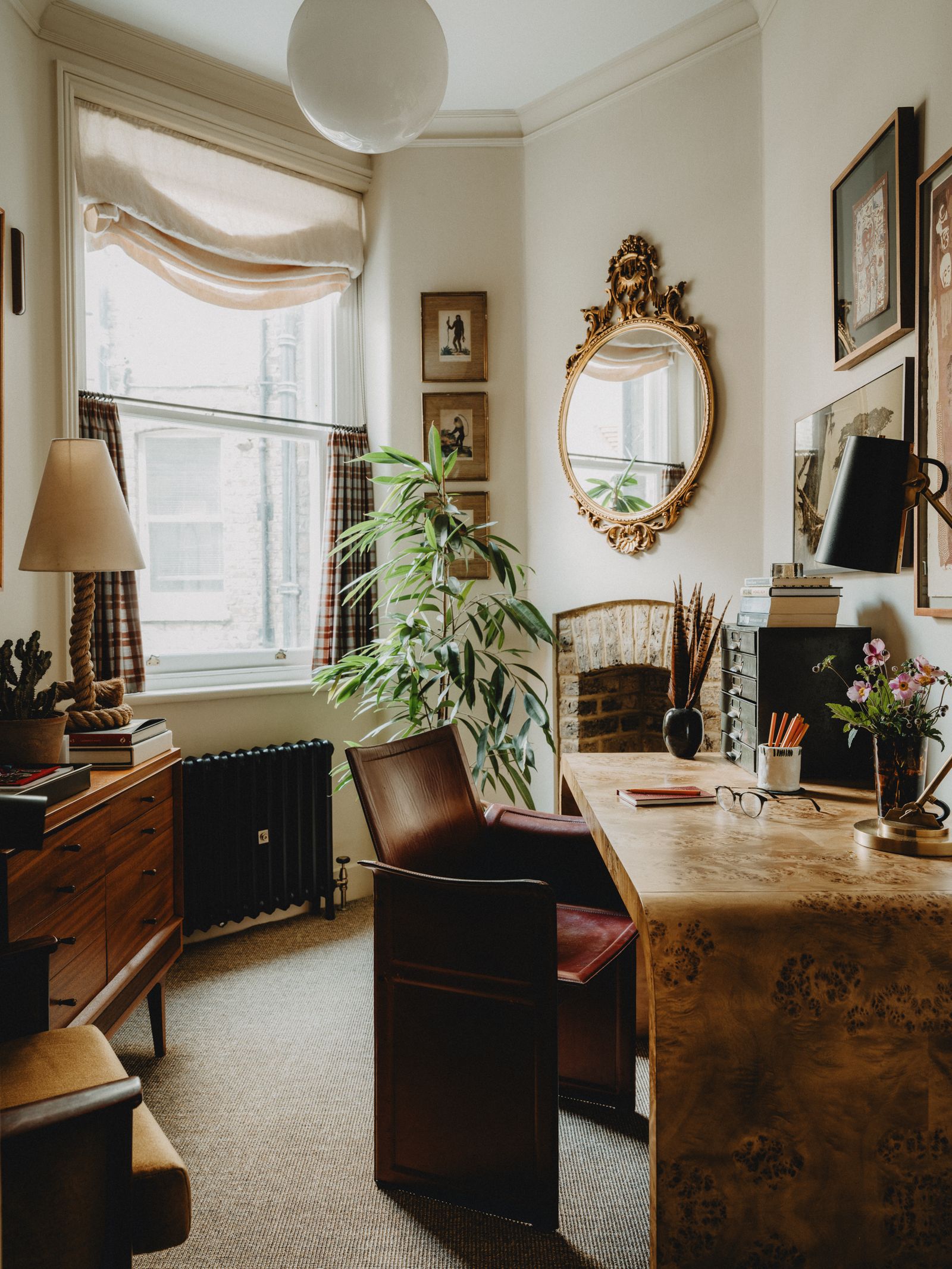 Image may contain Lamp Desk Furniture Table Plant Art Painting Chair Cup Book Publication and Indoors