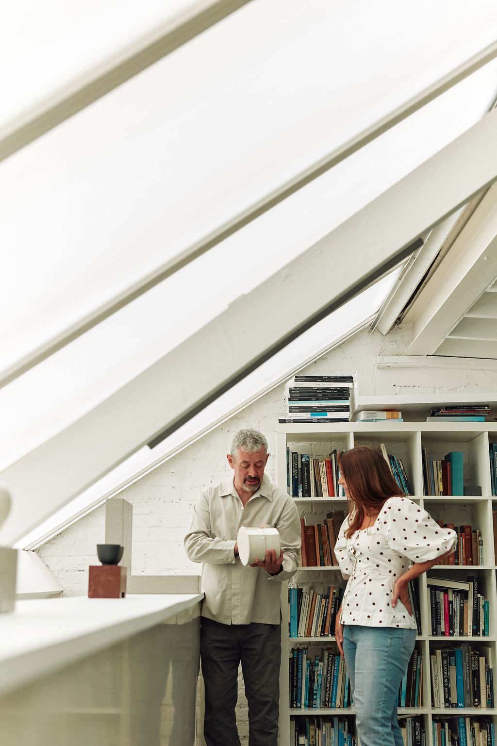 Image may contain Adult Person Book Indoors Library Publication Clothing Pants Furniture Shelf and Bookcase