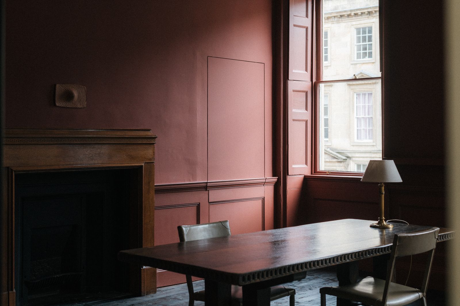 Image may contain Lamp Desk Furniture Table Fireplace Indoors Chair Interior Design Table Lamp and Dining Table