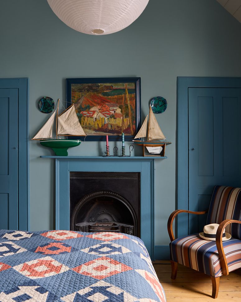 Image may contain: Fireplace, Indoors, Interior Design, Lamp, Art, Painting, Clothing, Hat, Chair, Furniture, and Home Decor