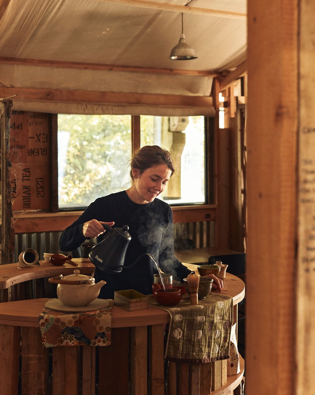 Image may contain Pottery Cookware Pot Lamp Adult Person Wood Cup Desk Furniture Table Face and Head