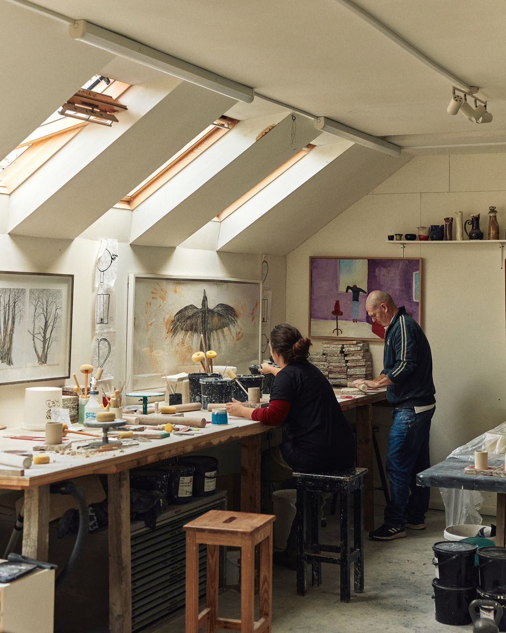 Image may contain Adult Person Clothing Footwear Shoe Desk Furniture Table Art Painting Cup and Architecture