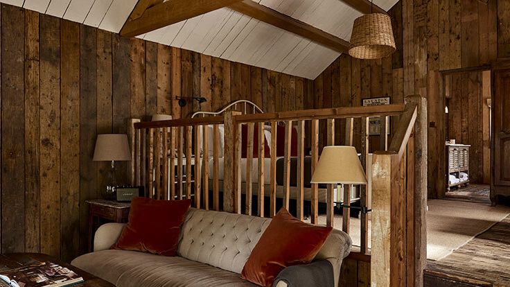 Image may contain: Indoors, Interior Design, Book, Publication, Wood, Hardwood, Stained Wood, Couch, Furniture, and Lamp