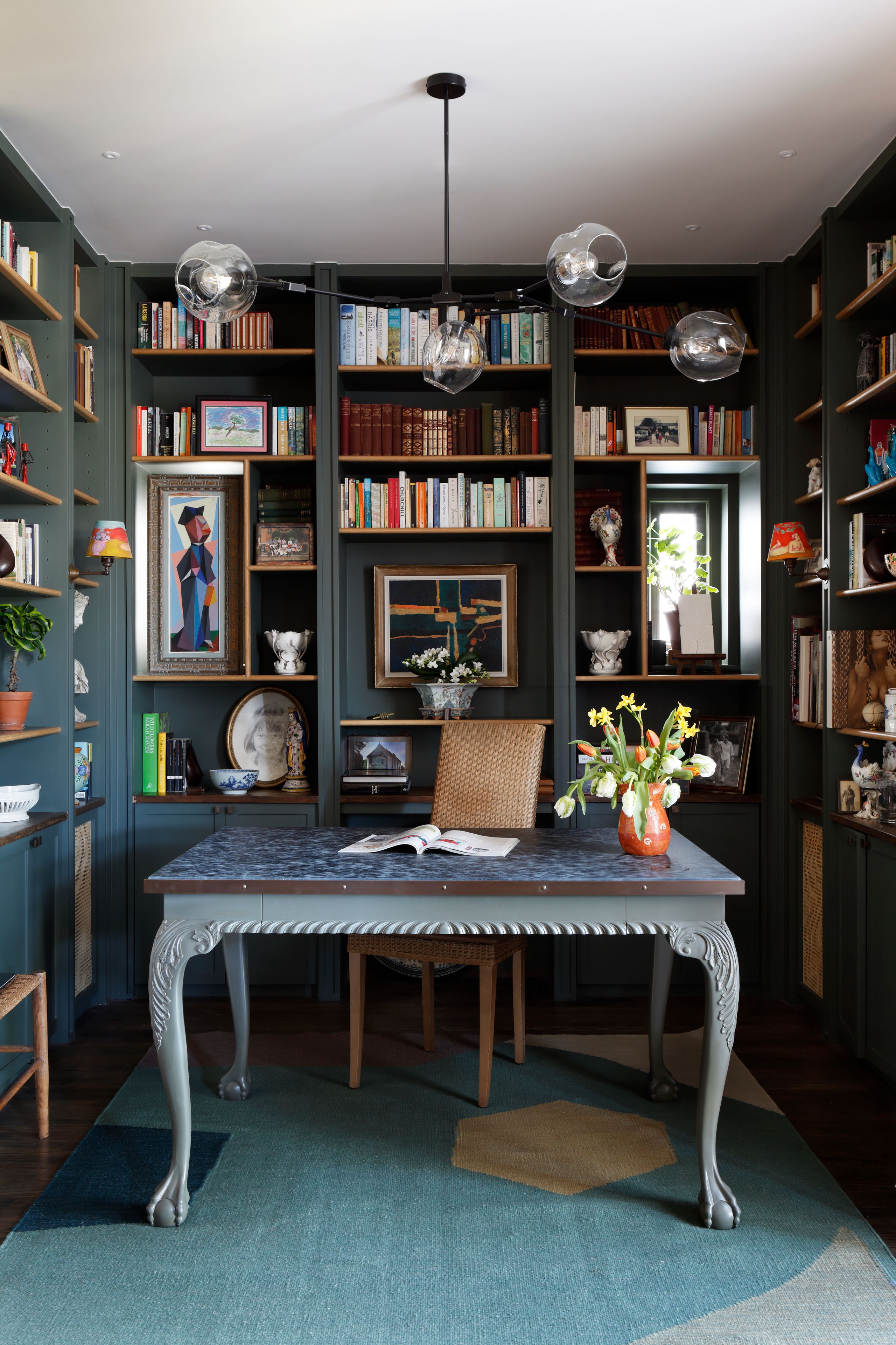 Image may contain: Book, Publication, Home Decor, Rug, Chair, Furniture, Desk, Table, Plant, Art, Painting, and Lamp