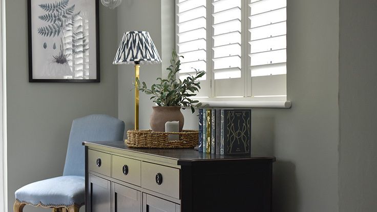 Image may contain: Furniture, Sideboard, Plant, Chair, Lamp, Art, Painting, Table Lamp, Home Decor, Cabinet, and Indoors