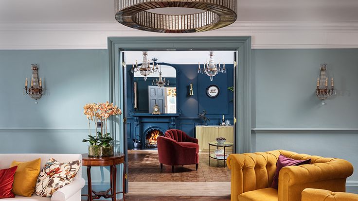 Image may contain: Architecture, Building, Furniture, Indoors, Living Room, Room, Home Decor, Couch, Lamp, and Chandelier