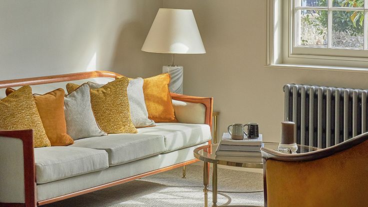 Image may contain: Couch, Furniture, Lamp, Cup, Architecture, Building, Indoors, Living Room, Room, Cushion, and Home Decor