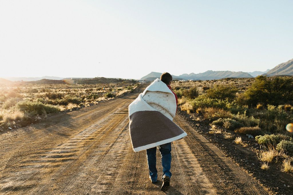 Image may contain: Person, Walking, Clothing, Footwear, Shoe, Blanket, Adult, and Pushing