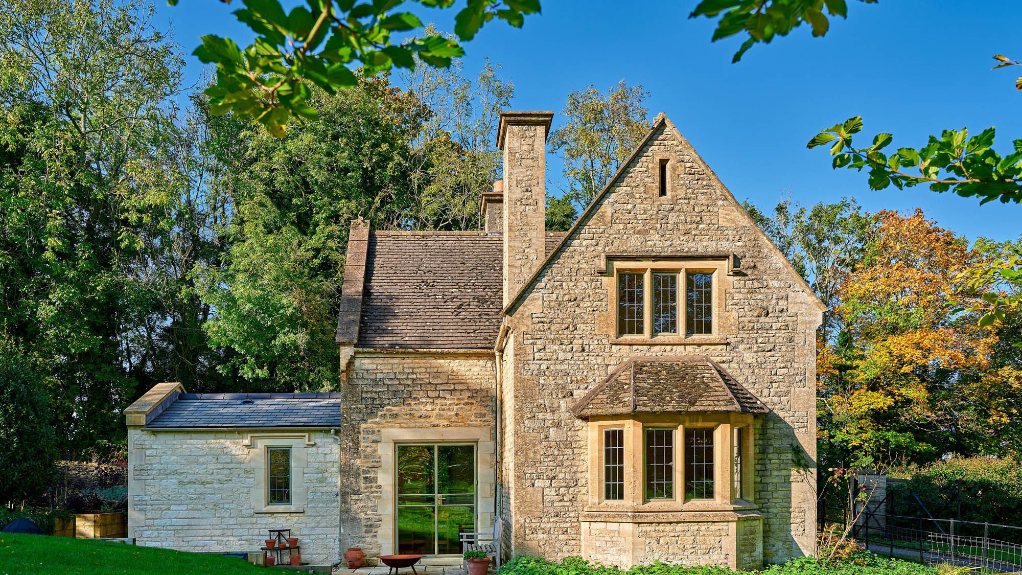 Image may contain: Architecture, Building, Housing, Plant, House, Manor, Cottage, Desk, Furniture, Table, and Grass