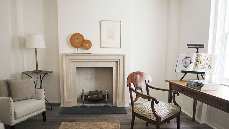 Image may contain: Chair, Furniture, Lamp, Desk, Table, Home Decor, Book, Publication, Fireplace, Indoors, and Rug