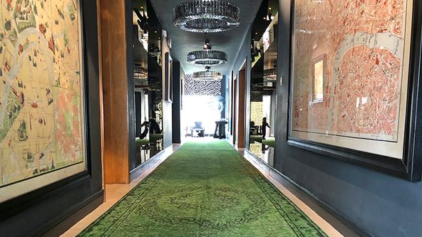 Image may contain: Floor, Indoors, Lamp, Architecture, Building, Corridor, Person, Chair, Furniture, Hallway, and Home Decor