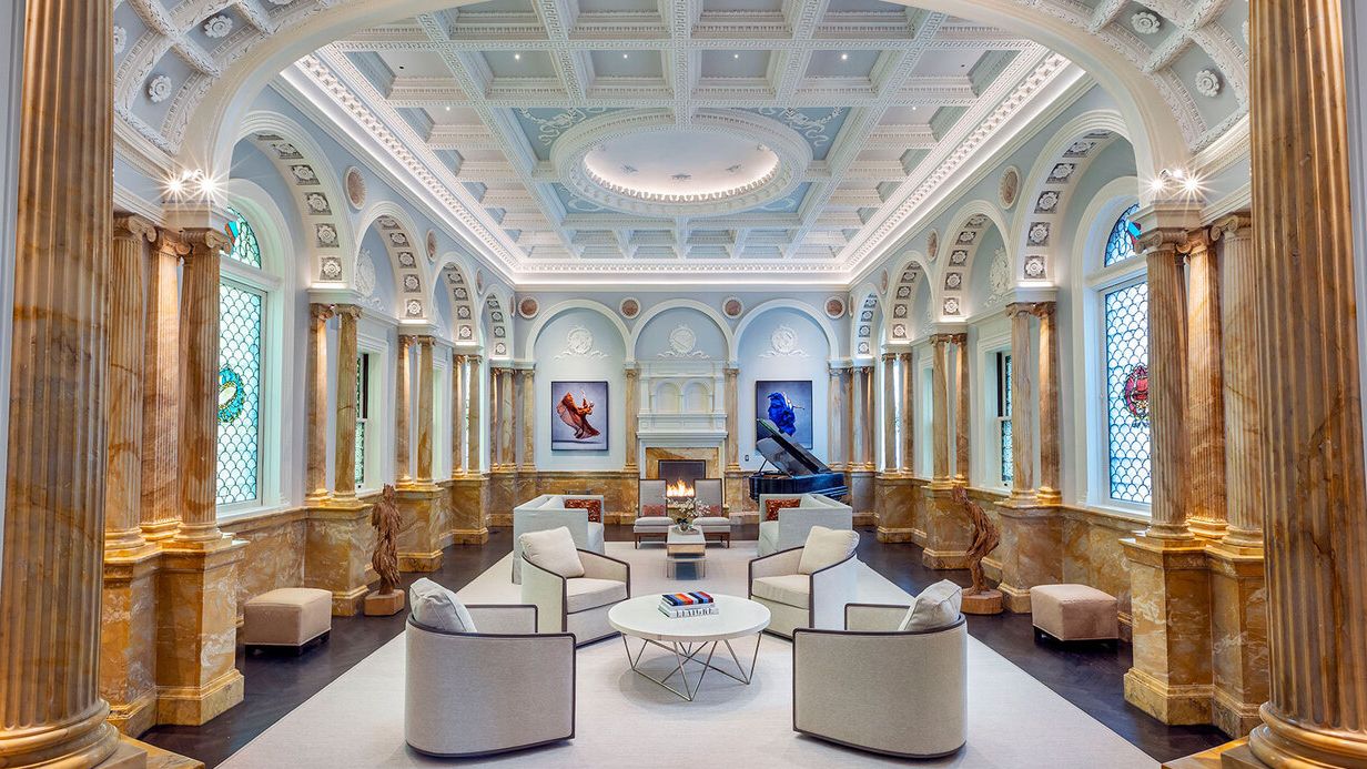 Image may contain: Indoors, Person, Home Decor, Rug, Chair, Furniture, Architecture, Building, Foyer, Bench, Couch, and Art