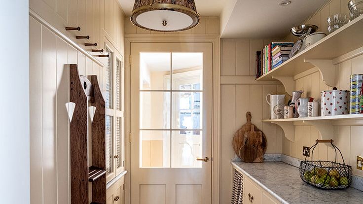 Image may contain: Indoors, Interior Design, Lamp, Cup, Shelf, Kitchen, and Pantry