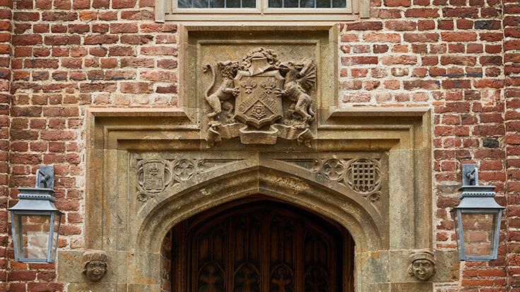 Image may contain: Brick, Arch, Architecture, Gothic Arch, Person, and Lamp