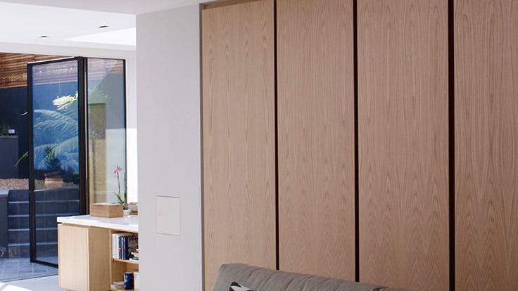 Image may contain: Indoors, Interior Design, Wood Panels, Couch, Furniture, and Door