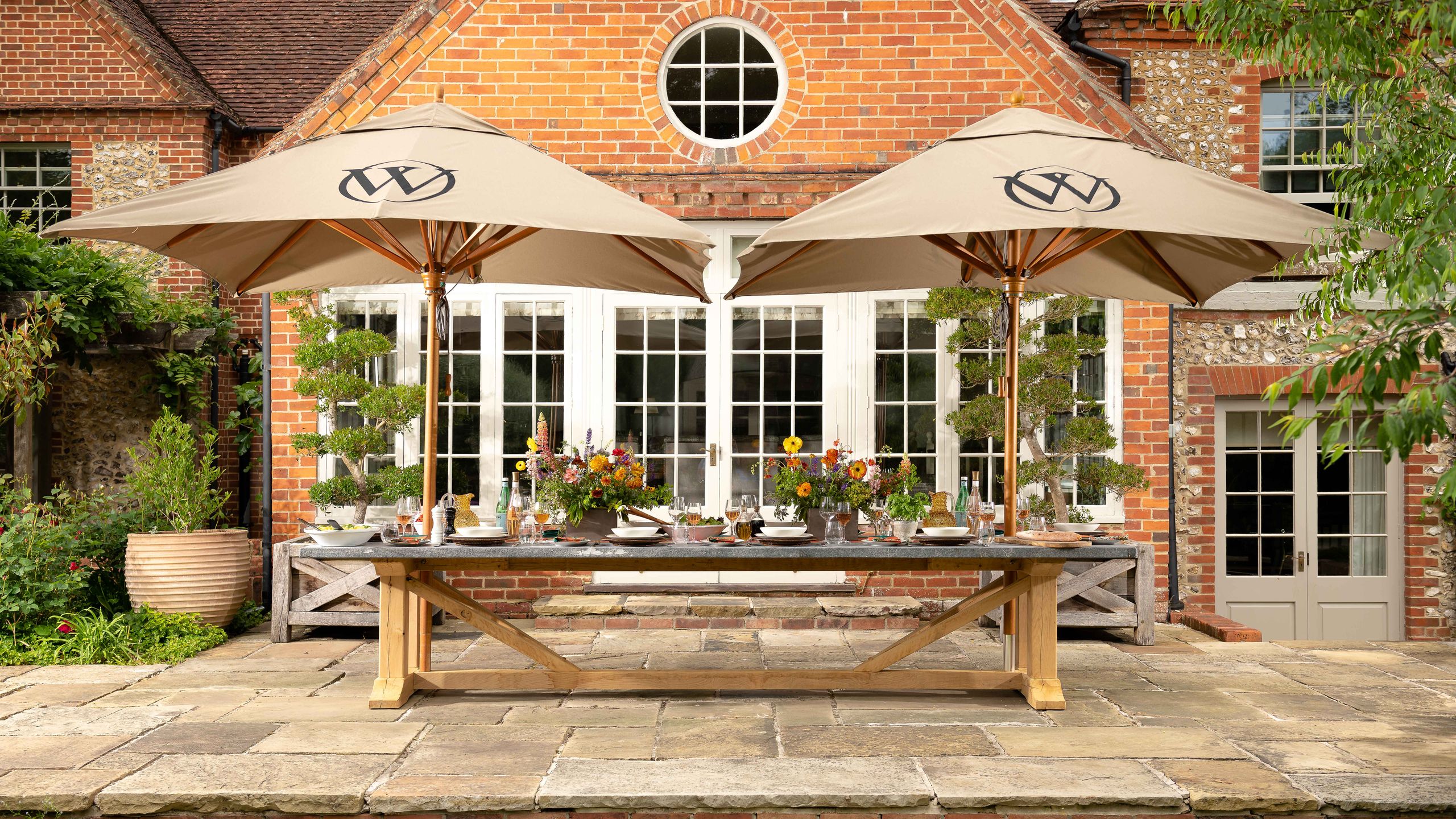 Image may contain: Architecture, Building, House, Housing, Patio, Path, Walkway, Plant, Canopy, Patio Umbrella, and Door