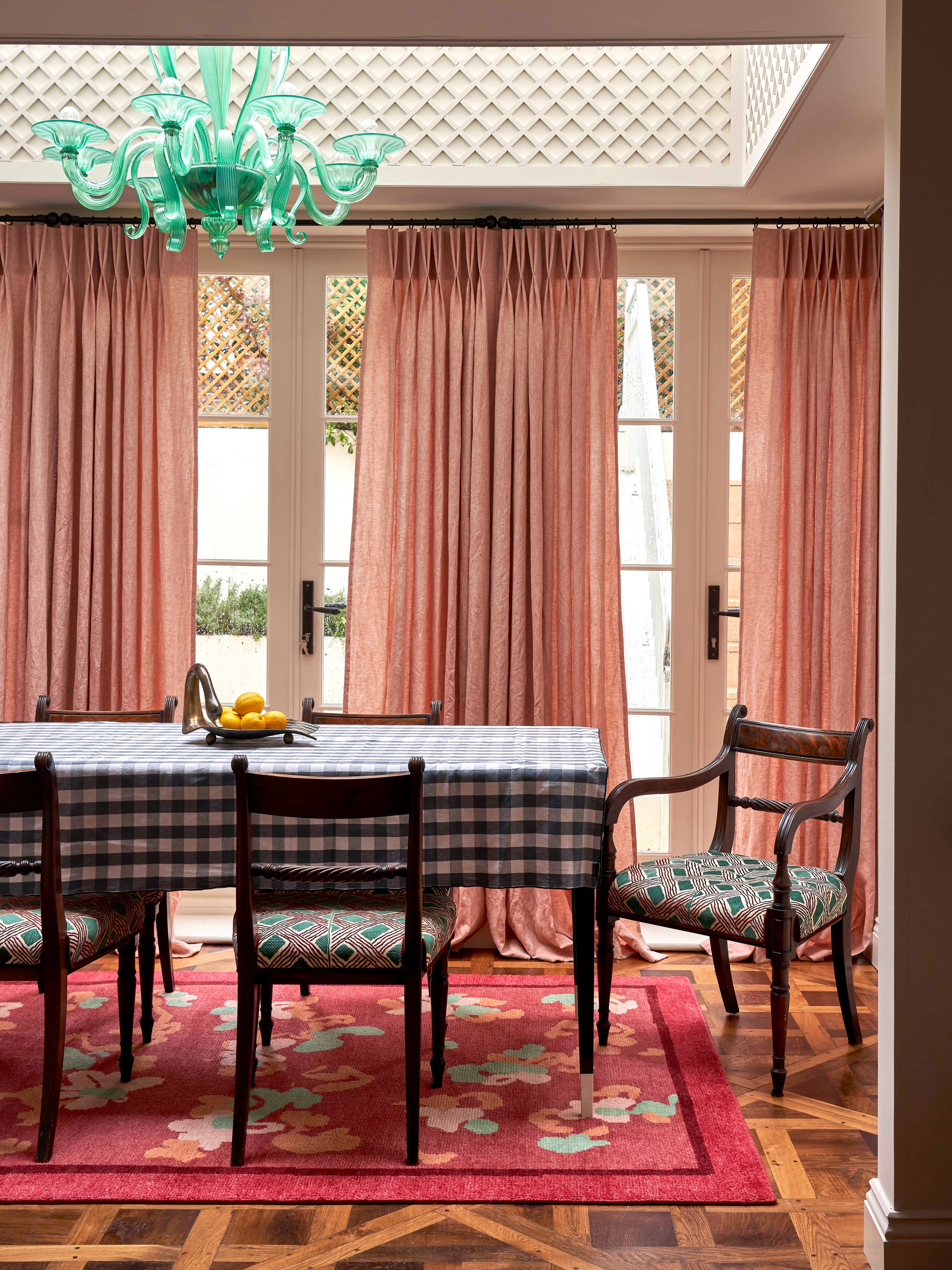 Image may contain: Home Decor, Chair, Furniture, Rug, Indoors, Interior Design, Chandelier, Lamp, Table, and Desk