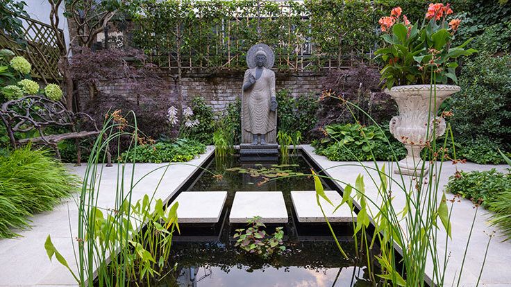 Image may contain: Nature, Outdoors, Pond, Water, Garden, Backyard, Yard, Person, Bench, Furniture, Grass, and Plant