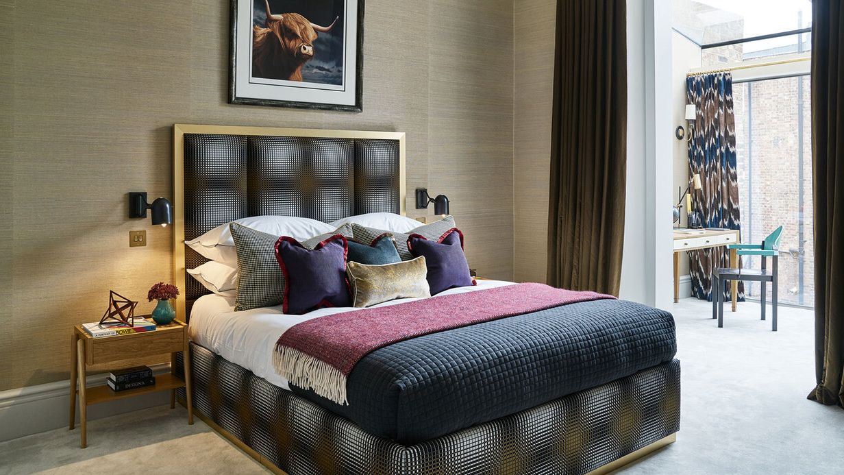 Image may contain: Indoors, Interior Design, Art, Painting, Bed, Furniture, Home Decor, Lamp, Chair, Cushion, and Bedroom