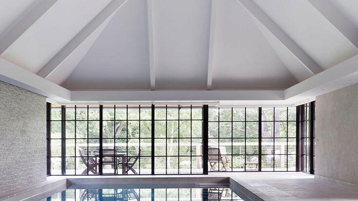 Image may contain: Chair, Furniture, Pool, Water, Indoors, Interior Design, Window, Swimming Pool, and French Window