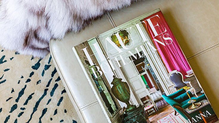 Image may contain: Coffee Table, Furniture, Table, Home Decor, Book, Publication, Rug, and Chair