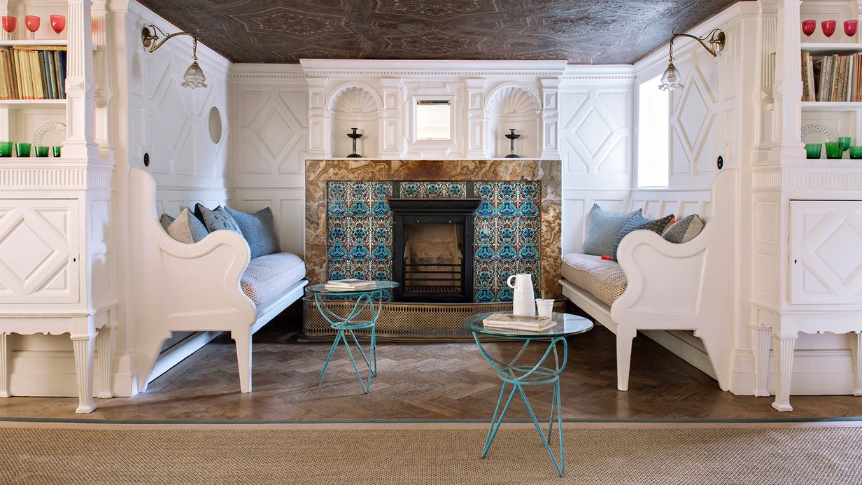 Image may contain: Home Decor, Indoors, Interior Design, Fireplace, Book, Publication, Desk, Furniture, Table, Rug, and Cup