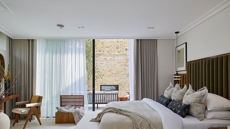 Image may contain: Indoors, Interior Design, Home Decor, Chair, Furniture, Plant, Desk, Table, Cushion, Bed, and Art