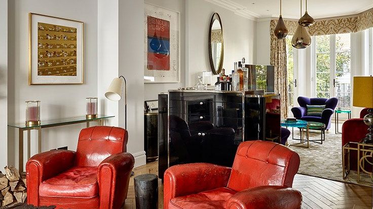 Image may contain: Art, Painting, Furniture, Lamp, Chair, Desk, Table, Couch, Armchair, Home Decor, Person, and Rug