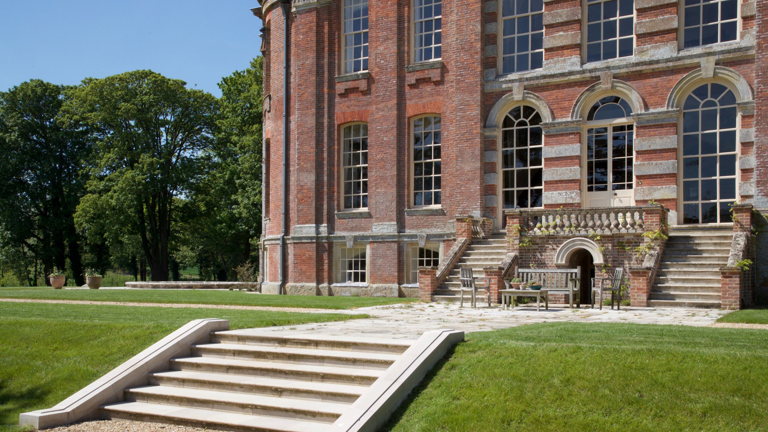 Image may contain: Grass, Plant, Lawn, Desk, Furniture, Table, Architecture, Building, Housing, and Campus