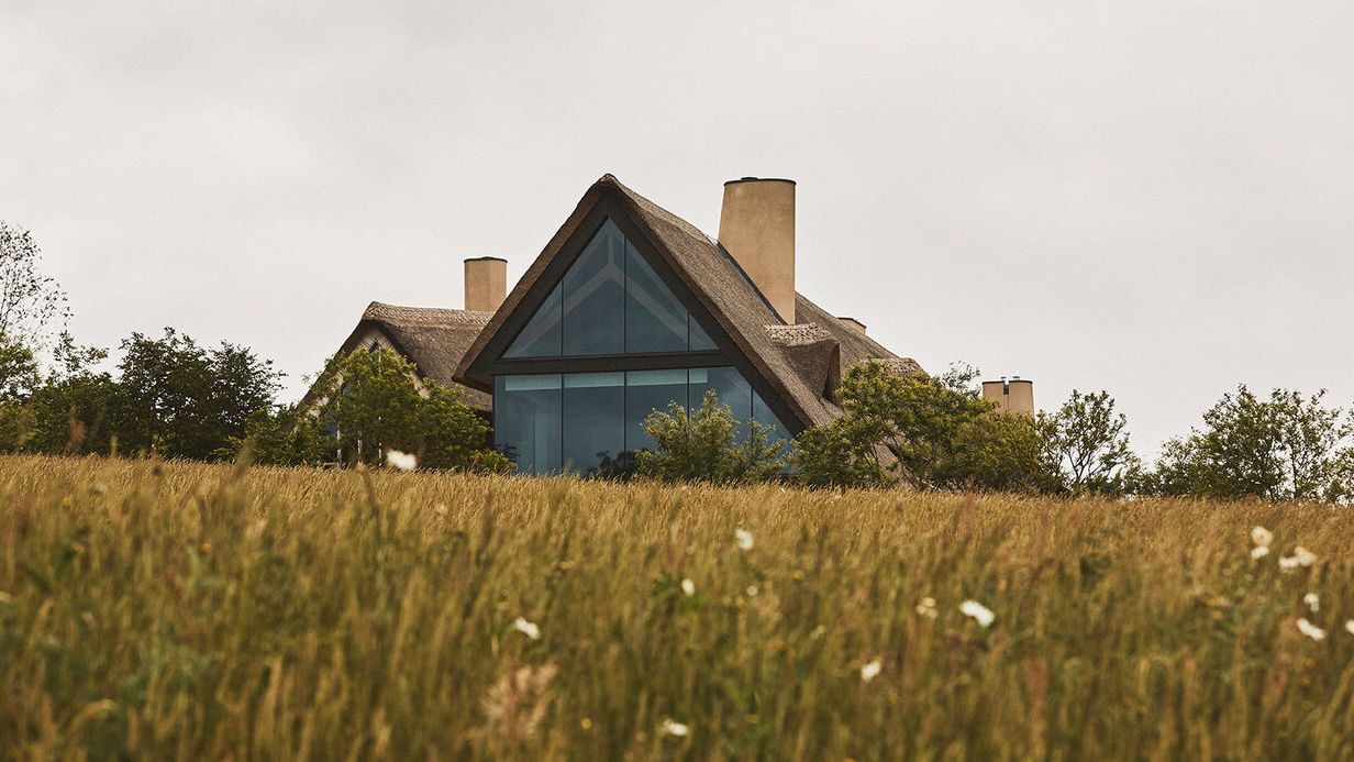 Image may contain: Architecture, Building, Cottage, House, Housing, Grass, Plant, Outdoors, Shelter, Field, and Grassland