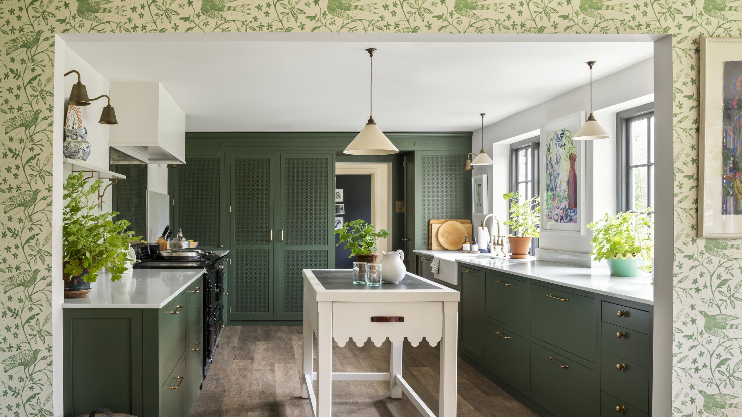 Image may contain: Indoors, Interior Design, Kitchen, Kitchen Island, Plant, Lamp, Art, and Painting