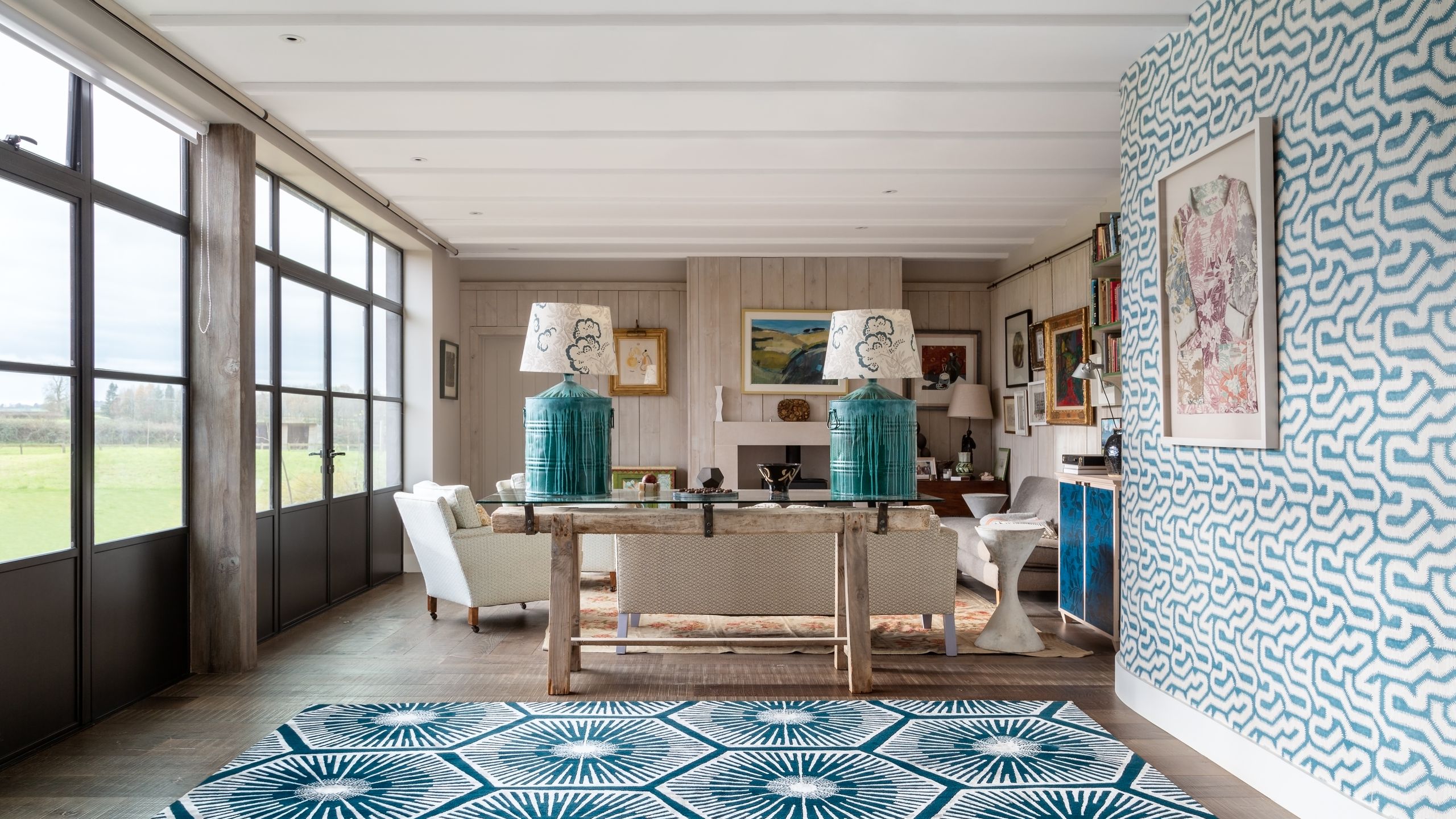 Image may contain: Home Decor, Rug, Art, Painting, Lamp, Indoors, Interior Design, Furniture, Table, Floor, and Architecture