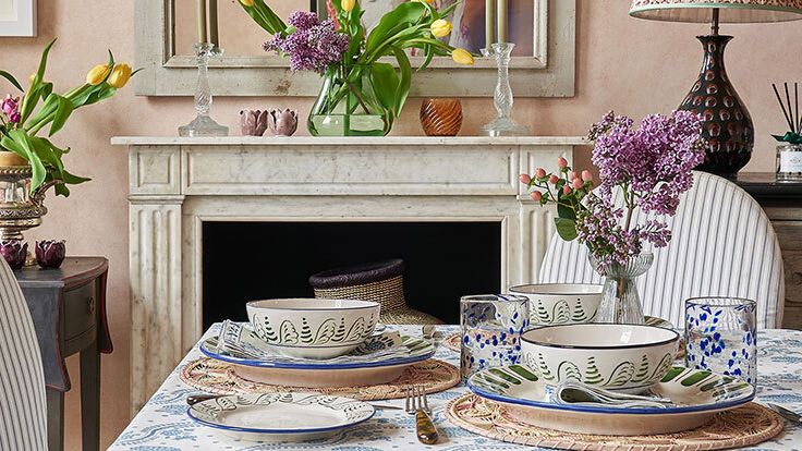 Image may contain: Tablecloth, Furniture, Table, Tabletop, Cup, Dining Table, Lamp, Plate, Chair, Architecture, and Building