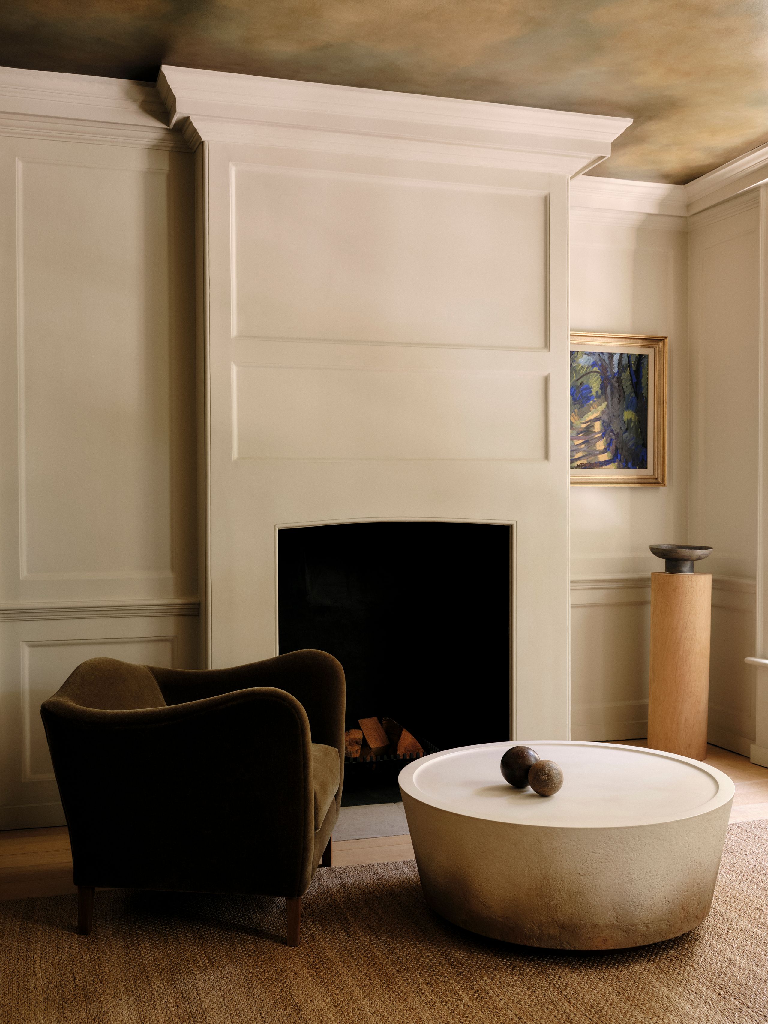 Image may contain: Fireplace, Indoors, Interior Design, Furniture, Hearth, Art, Painting, Chair, Table, Bathing, and Bathtub