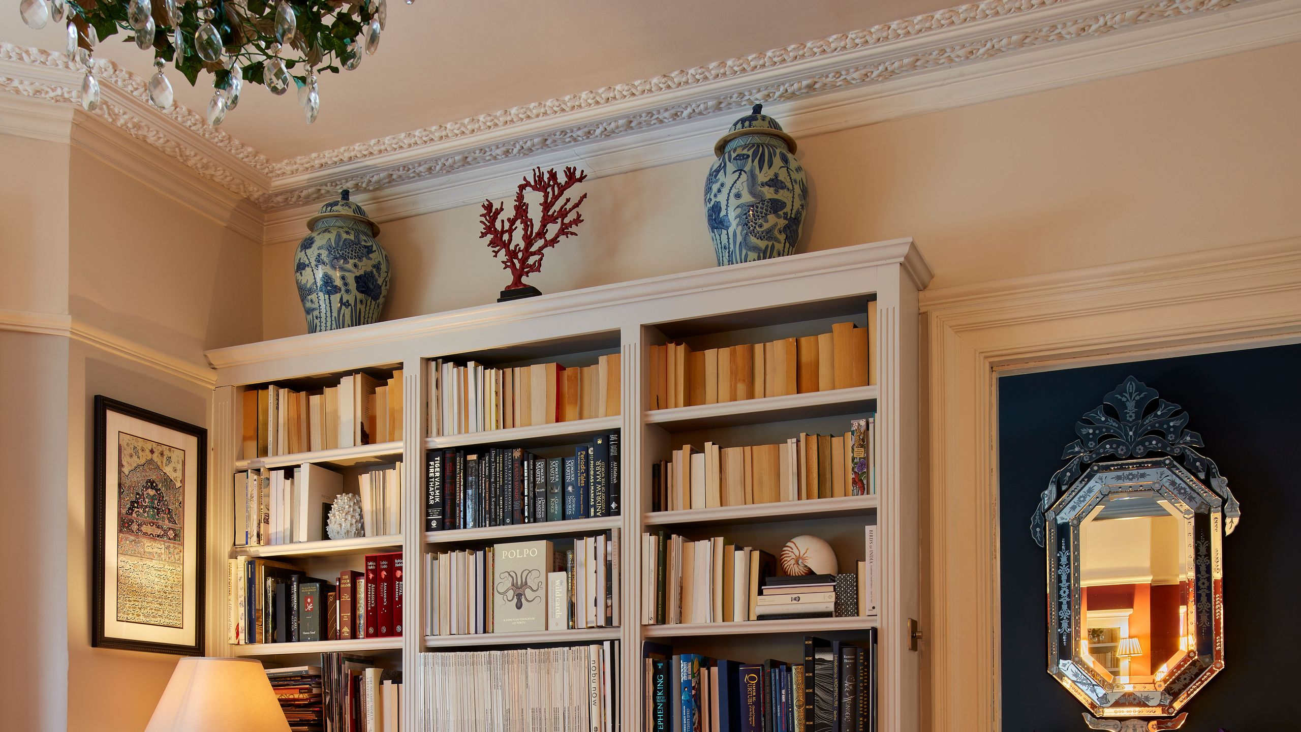 Image may contain: Lamp, Furniture, Desk, Table, Bookcase, Home Decor, Rug, Art, and Painting