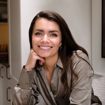 Image may contain: Head, Person, Face, Happy, Smile, Dimples, Adult, Body Part, Neck, Accessories, Bag, and Handbag