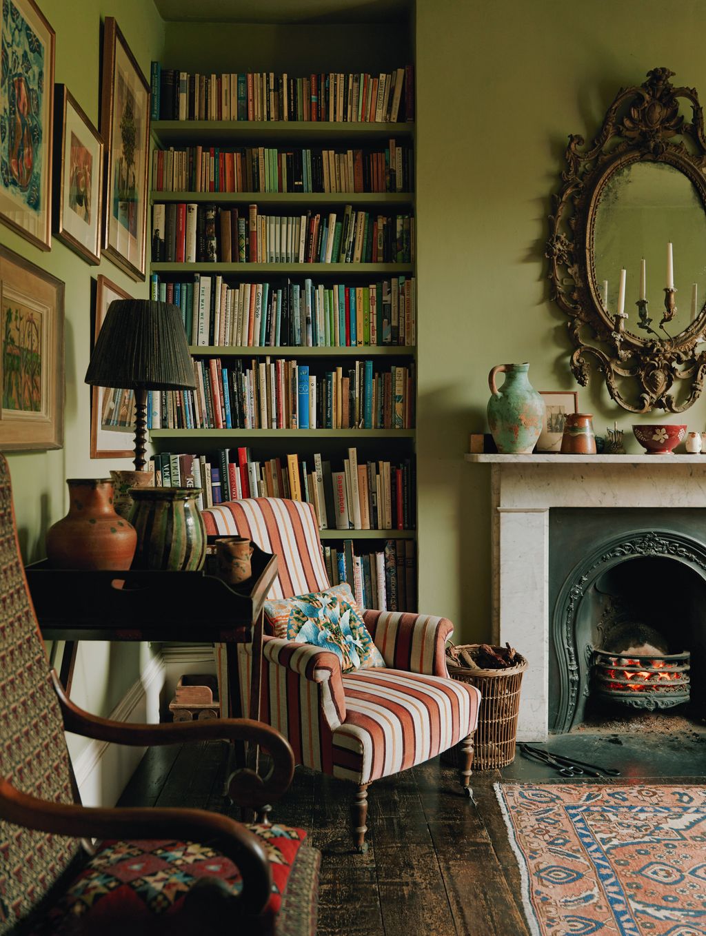 Image may contain Furniture Chair Home Decor Rug Bookcase Art Painting Candle Cup and Lamp