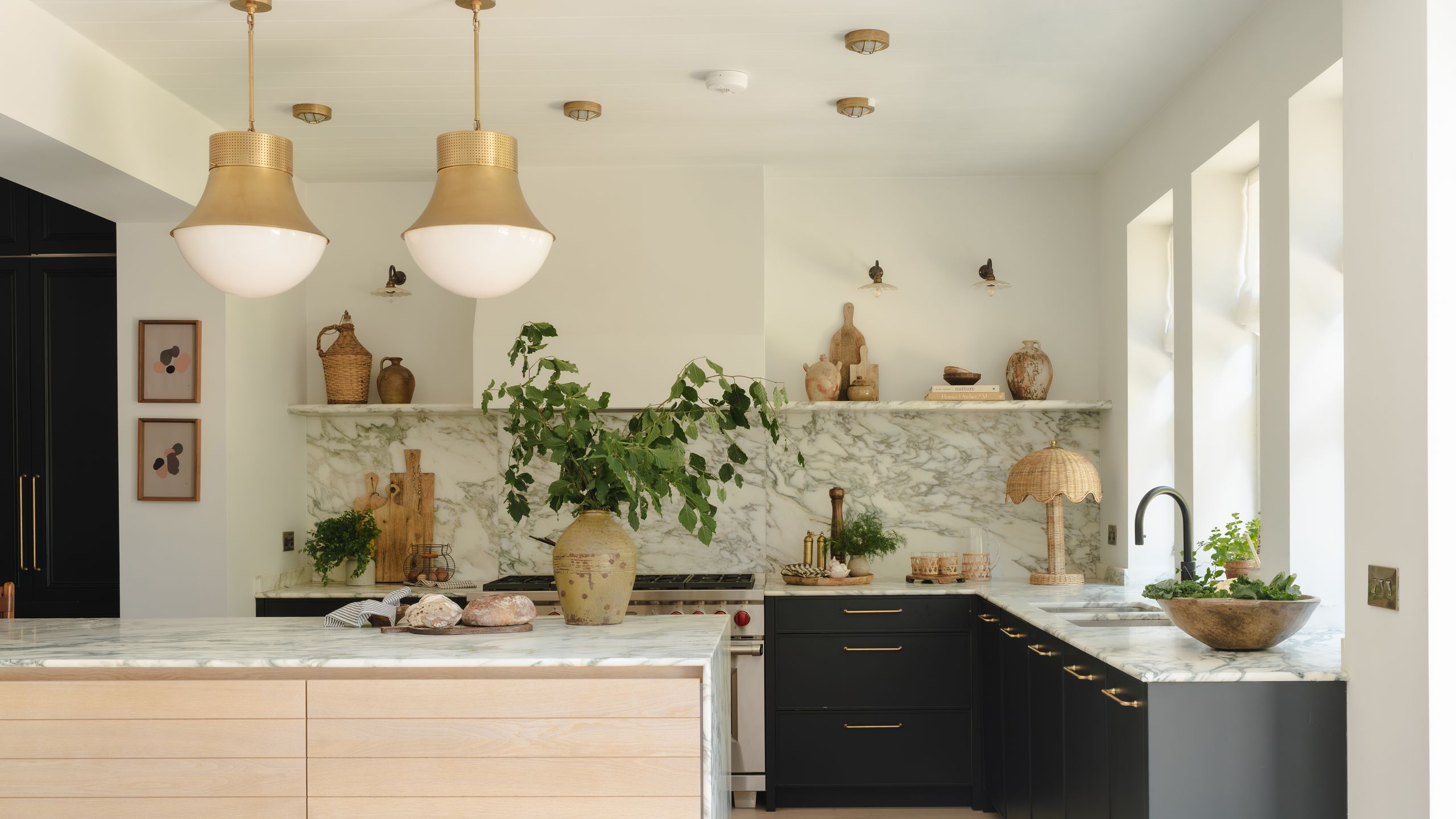 Image may contain: Indoors, Interior Design, Kitchen, Kitchen Island, Person, Plant, Sink, Sink Faucet, Lamp, and Art