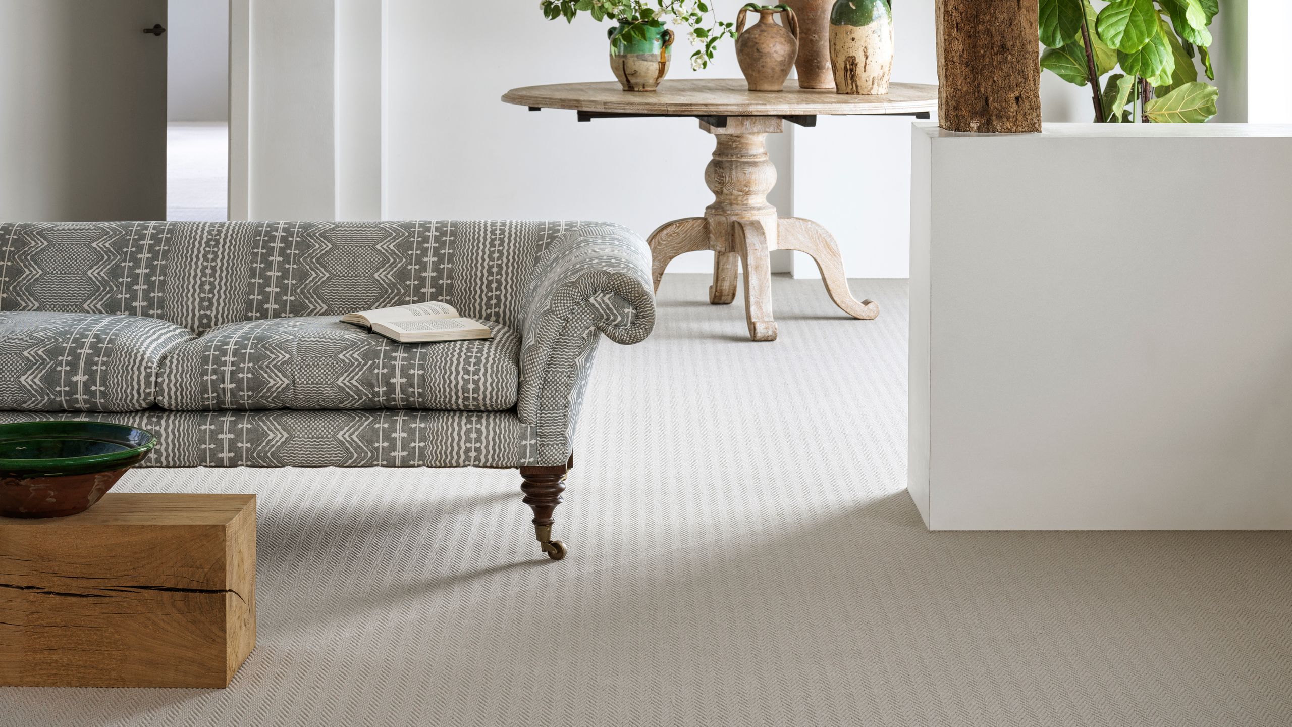 Image may contain: Floor, Home Decor, Coffee Table, Furniture, Table, Flooring, Rug, Book, Publication, and Plant