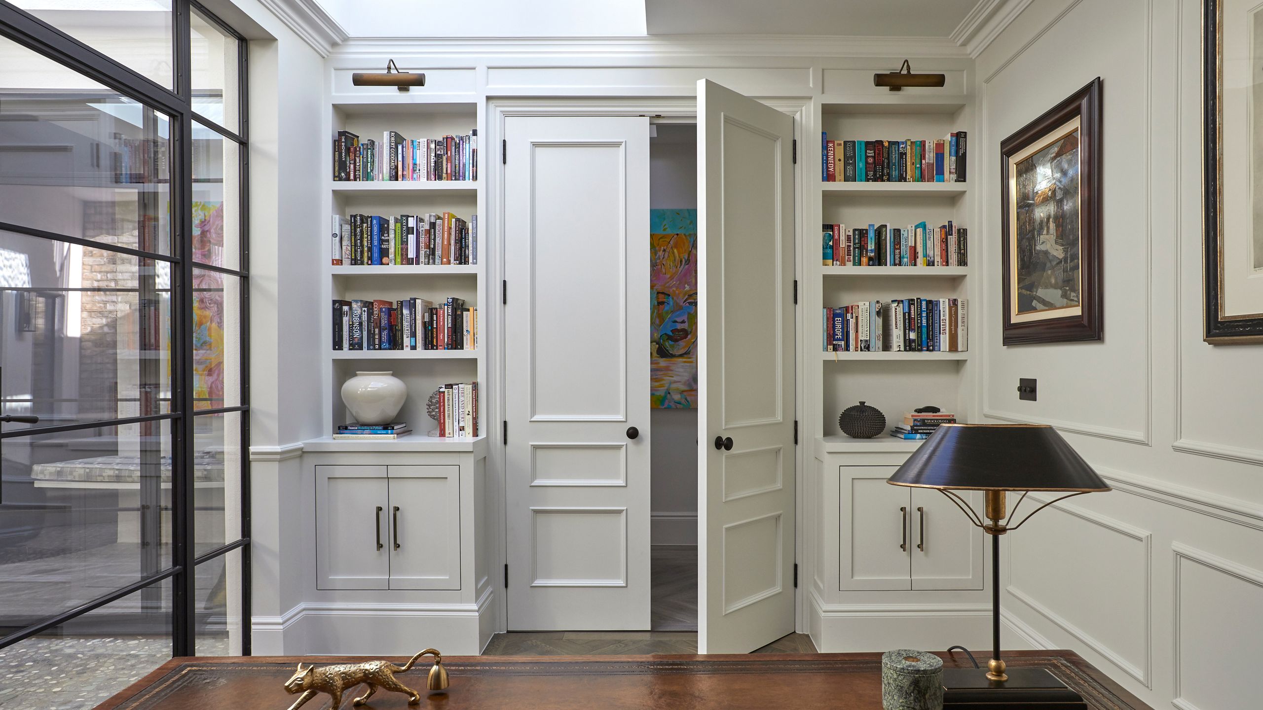 Image may contain: Lamp, Door, Indoors, Interior Design, Furniture, Art, Painting, and Bookcase