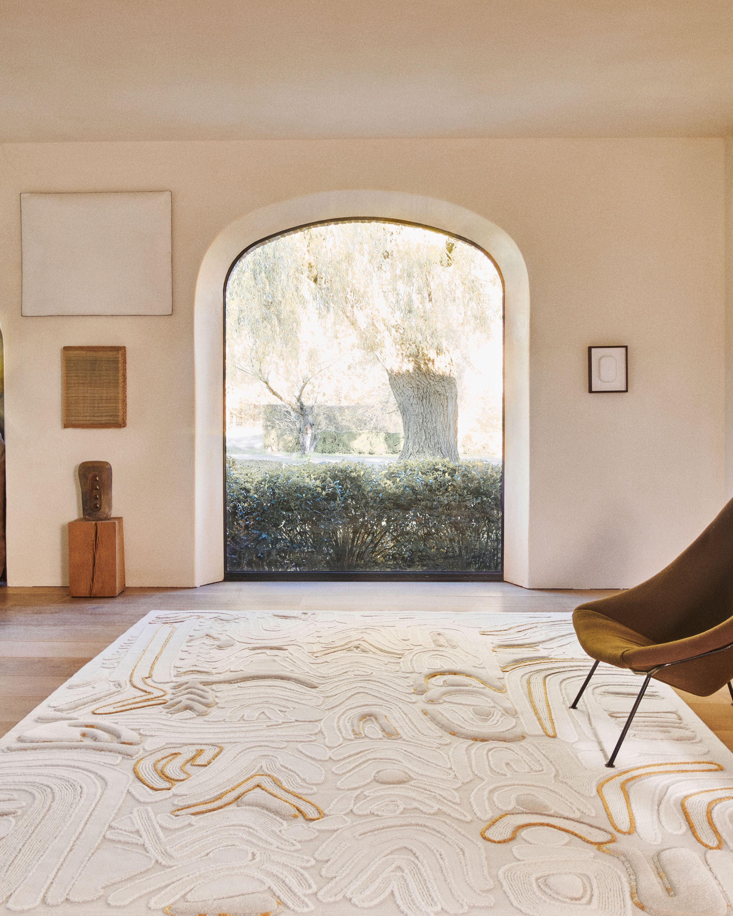 Image may contain: Home Decor, Rug, Chair, Furniture, Floor, Arch, Architecture, and Indoors