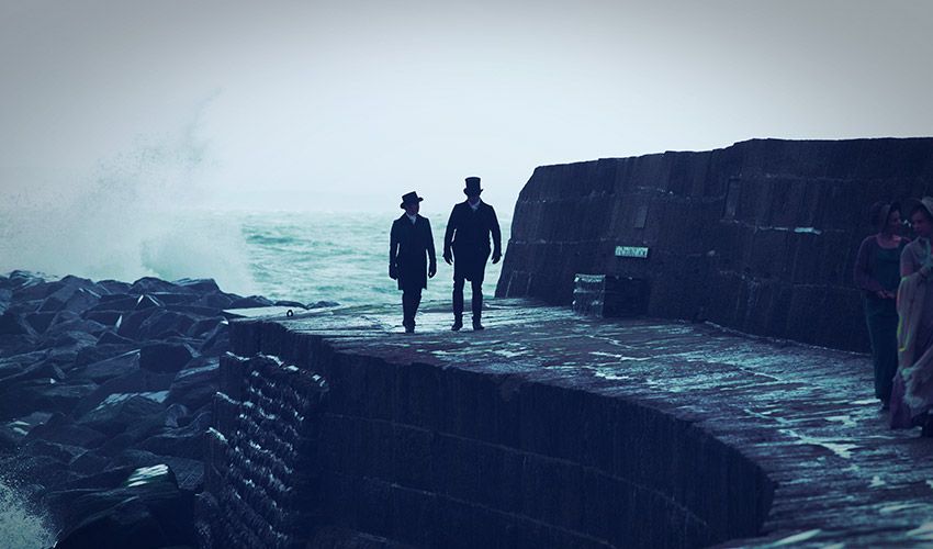 Image may contain Person Walking Rock Nature Outdoors Sea Water Clothing Coat and Hat