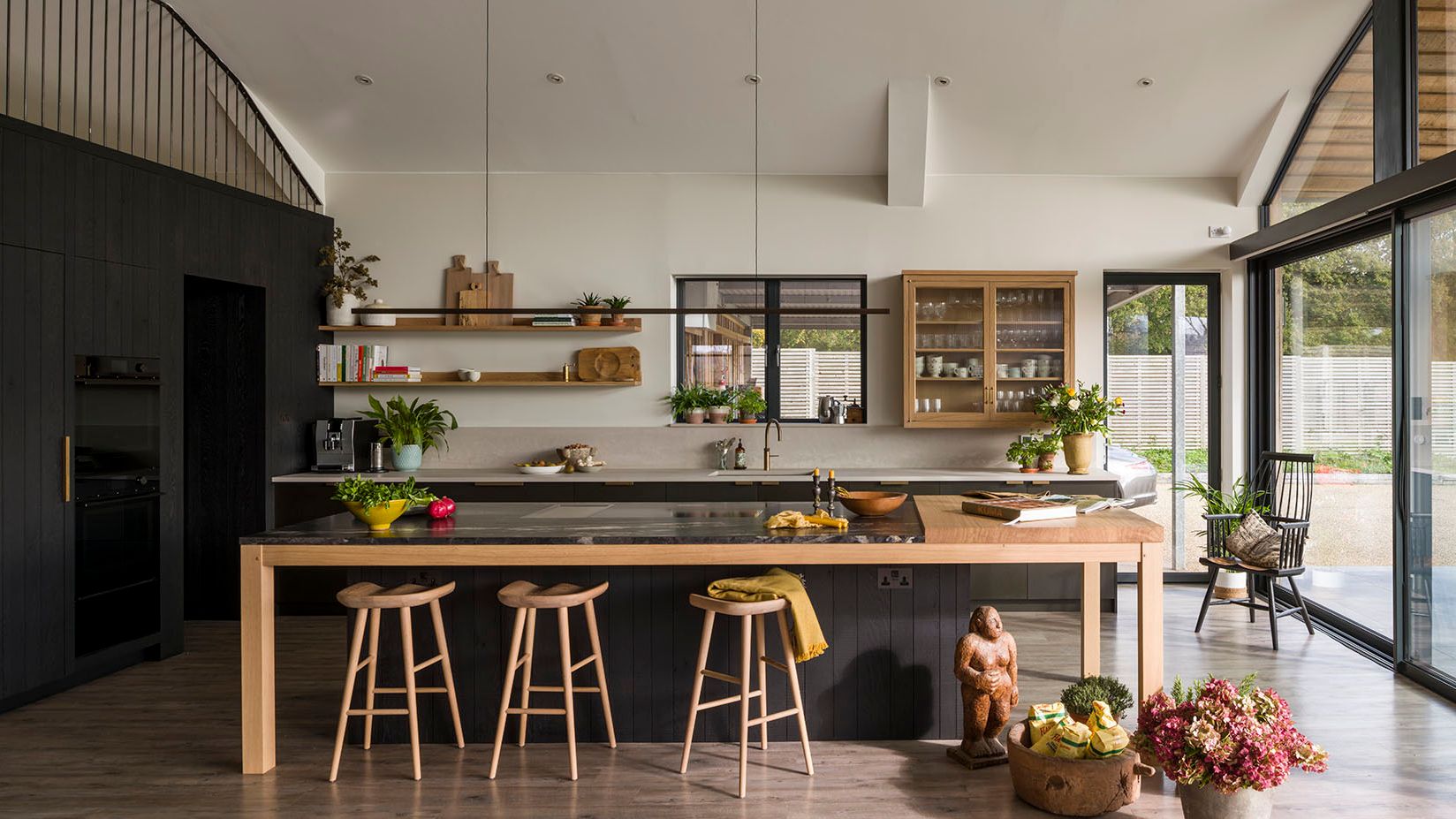 Image may contain: Indoors, Interior Design, Kitchen, Plant, Chair, Furniture, Kitchen Island, Person, Accessories, and Bag