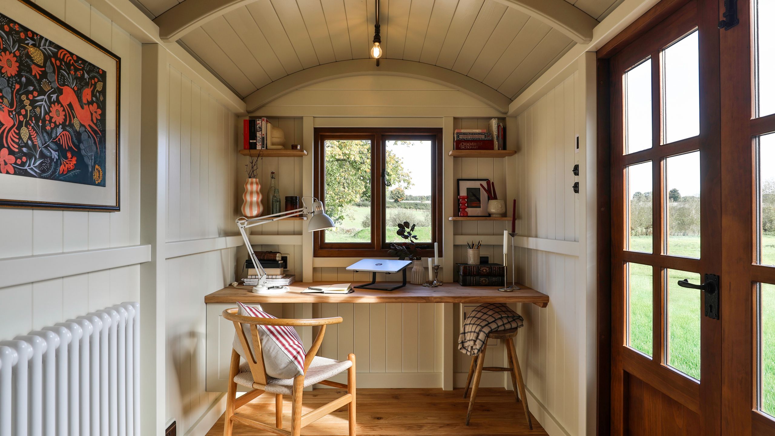 Image may contain: Indoors, Interior Design, Chair, Furniture, Lamp, Table, Art, Painting, Wood, Door, Desk, and Architecture